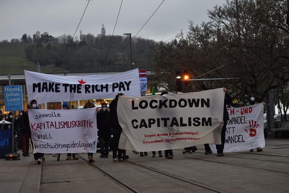 Frontblock der Demonstration lockdown capitalism in der Würzburger Kaiserstraße. Zu sehen sind vier Transparente mit der Aufschrift: Kapitalismuskritik statt Verschwörungsideologien, Lockdown Capitalism, System- und Strukturwandel statt Klimawandel und make the rich pay